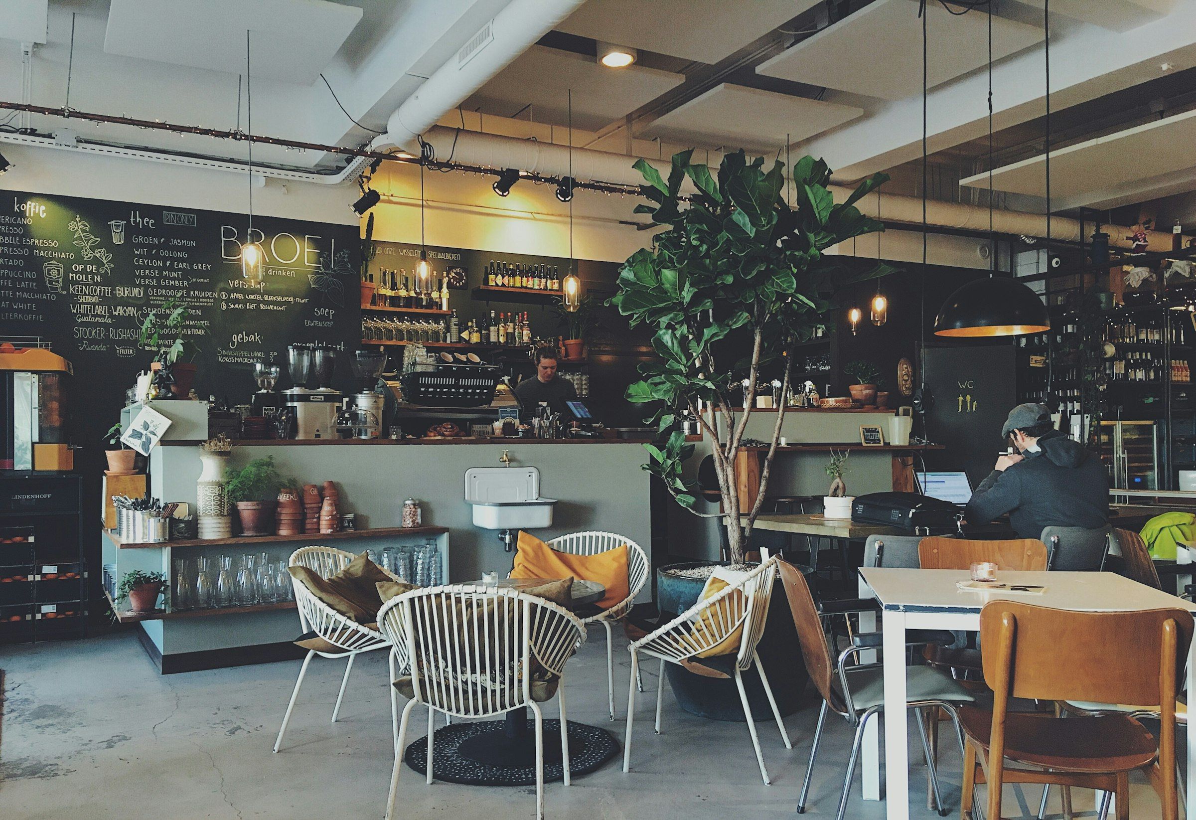 A warm, sunlit corner of the Kurado coffee roastery with a wooden counter.