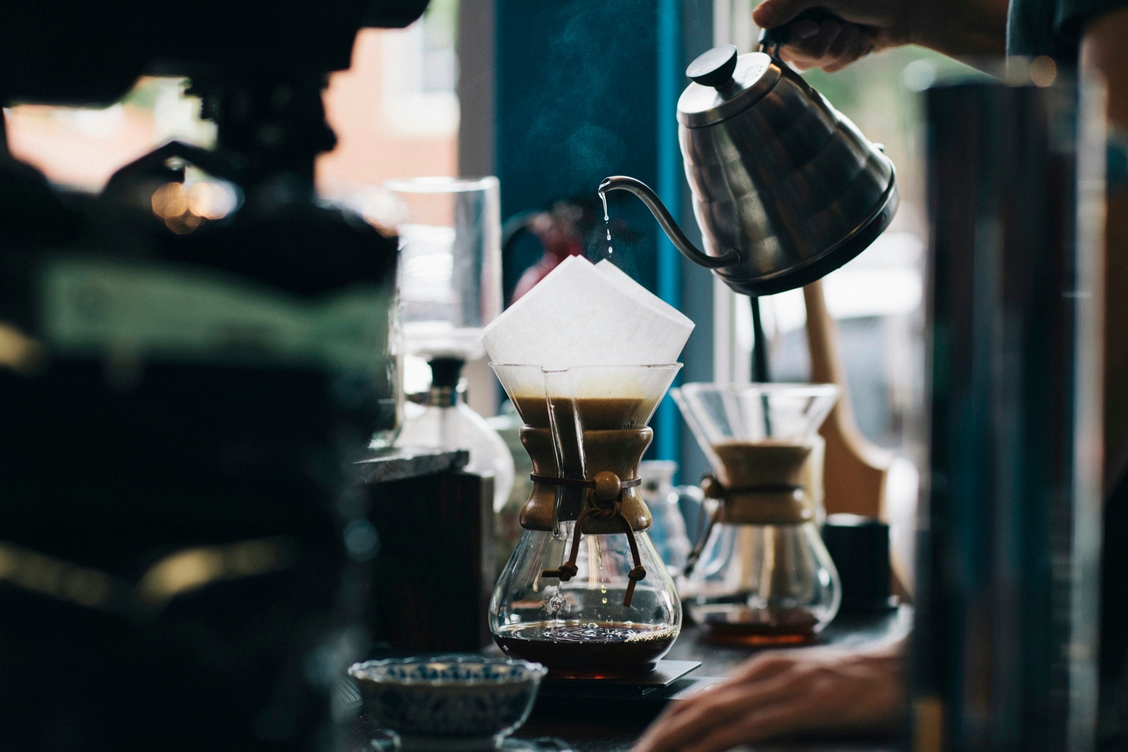 Freshly roasted coffee beans being scooped from a roaster.